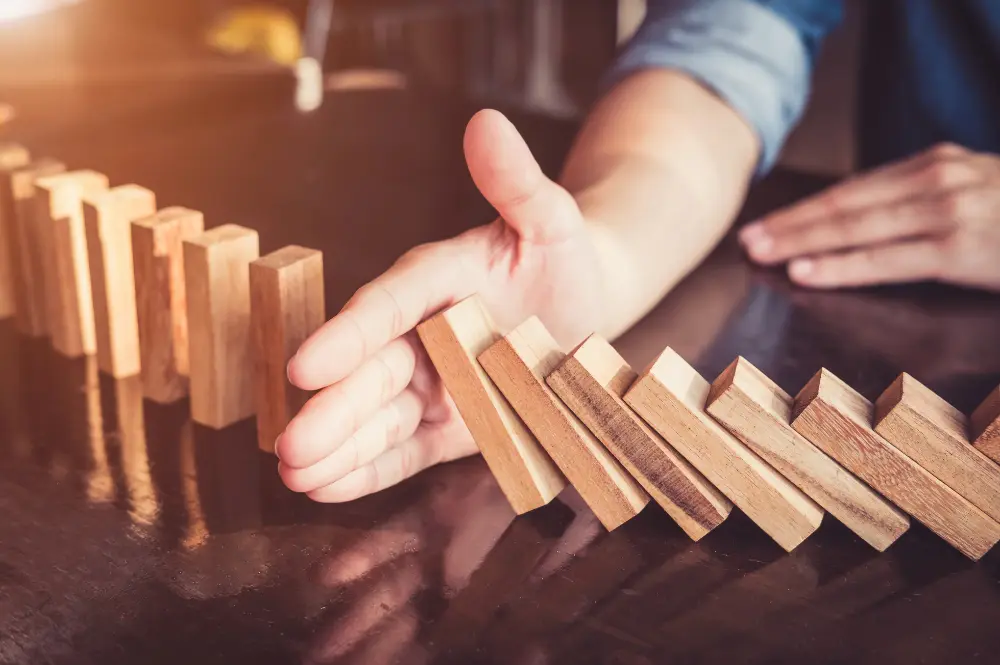 A person holds wooden blocks, symbolizing the concept of sequence of returns risk in investment strategies.