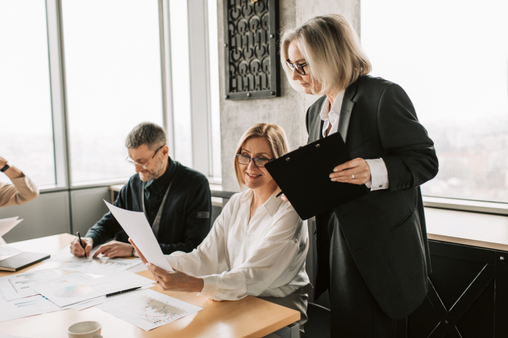 Business professionals collaborating in an office setting, discussing health savings accounts (HSA) and flexible spending accounts (FSA).